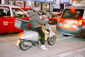 Person on scooter in traffic at night
