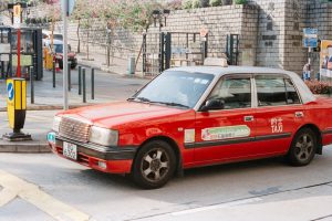Red taxi with chinese characters on the side.