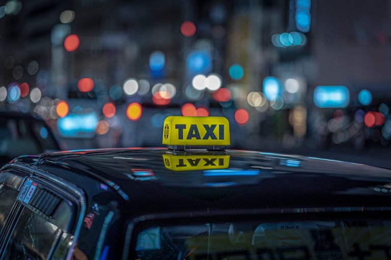 a taxi cab with a yellow taxi sign on top of it