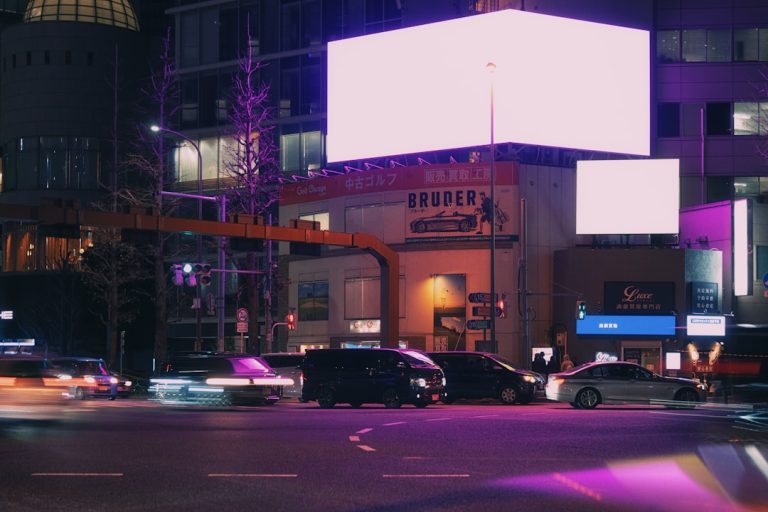Cars driving on a street at night with neon lights